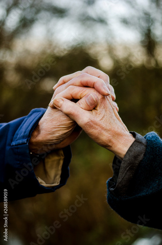 Older married couple holding hands in nature