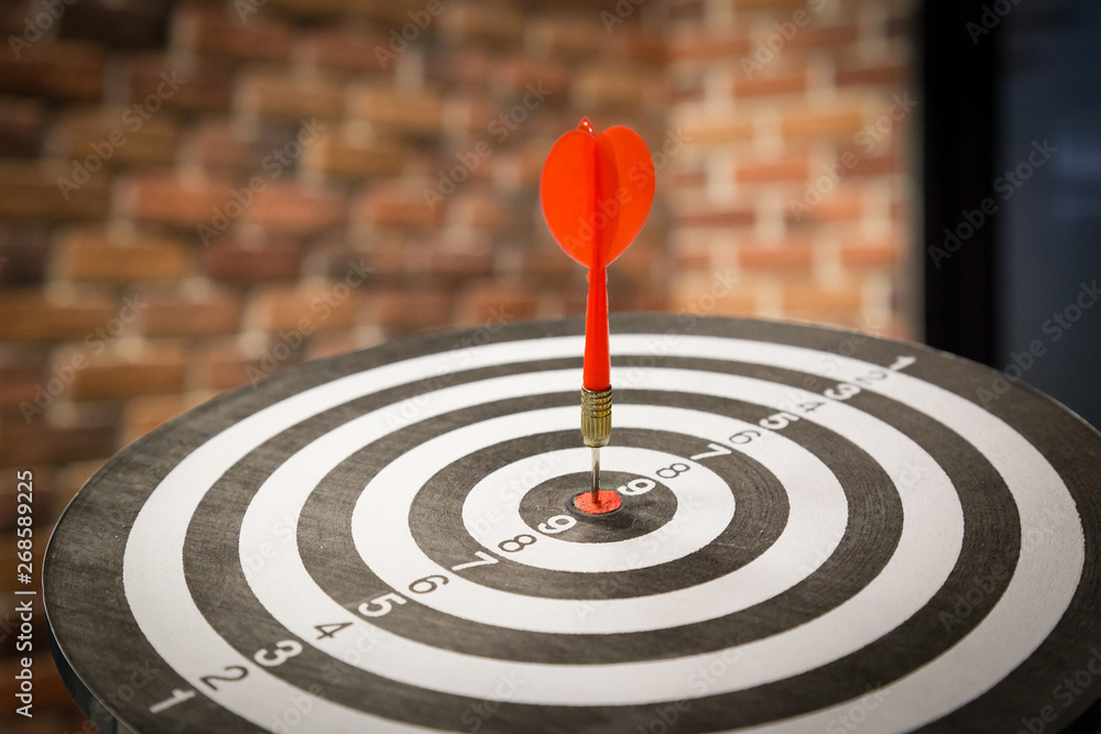 Red dart arrow hitting in the target center of dartboard on bullseye with sun light vintage style, Target marketing and business success concept - Image. Red dart arrow hitting in the target center of dartboard on bullseye with sun light vintage style, Target marketing and business success concept - Image.