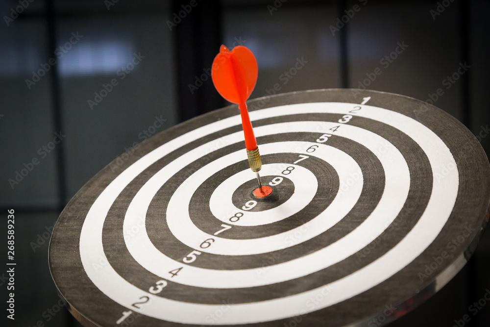 Red dart arrow hitting in the target center of dartboard on bullseye with sun light vintage style, Target marketing and business success concept - Image. Red dart arrow hitting in the target center of dartboard on bullseye with sun light vintage style, Target marketing and business success concept - Image.