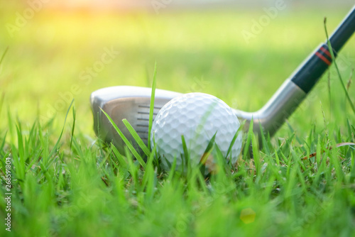 Golf ball and golf club in beautiful golf course at Thailand. Collection of golf equipment resting on green grass with green background