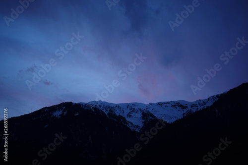 mountain ridge covered with snow-capped peaks winter night