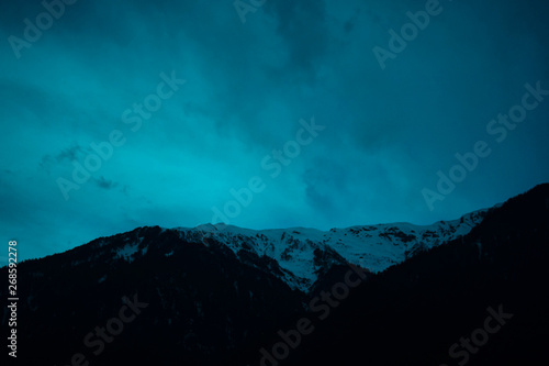 mountain ridge covered with snow-capped peaks winter night