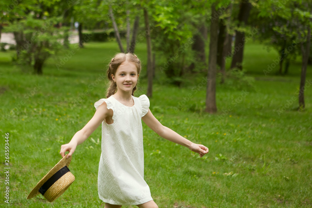 smiling little girl with hat plays and dances in summer day outdoors smiling little girl with hat plays and dances in summer day outdoors