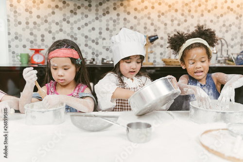 Group of kids are preparing the bakery in the kitchen .Children learning to cooking cookies