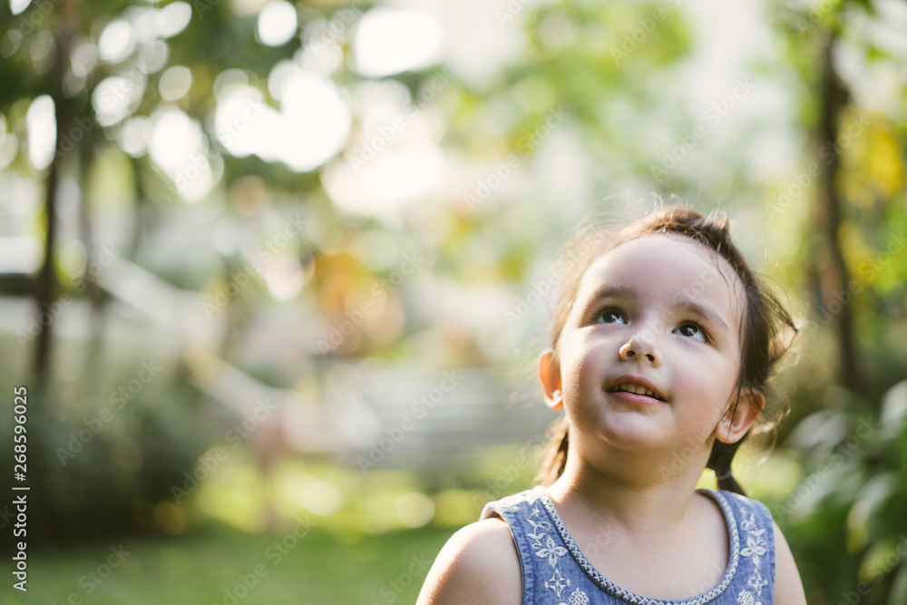 portrait little girl in nature park . cute kids looking up portrait little girl in nature park . cute kids looking up