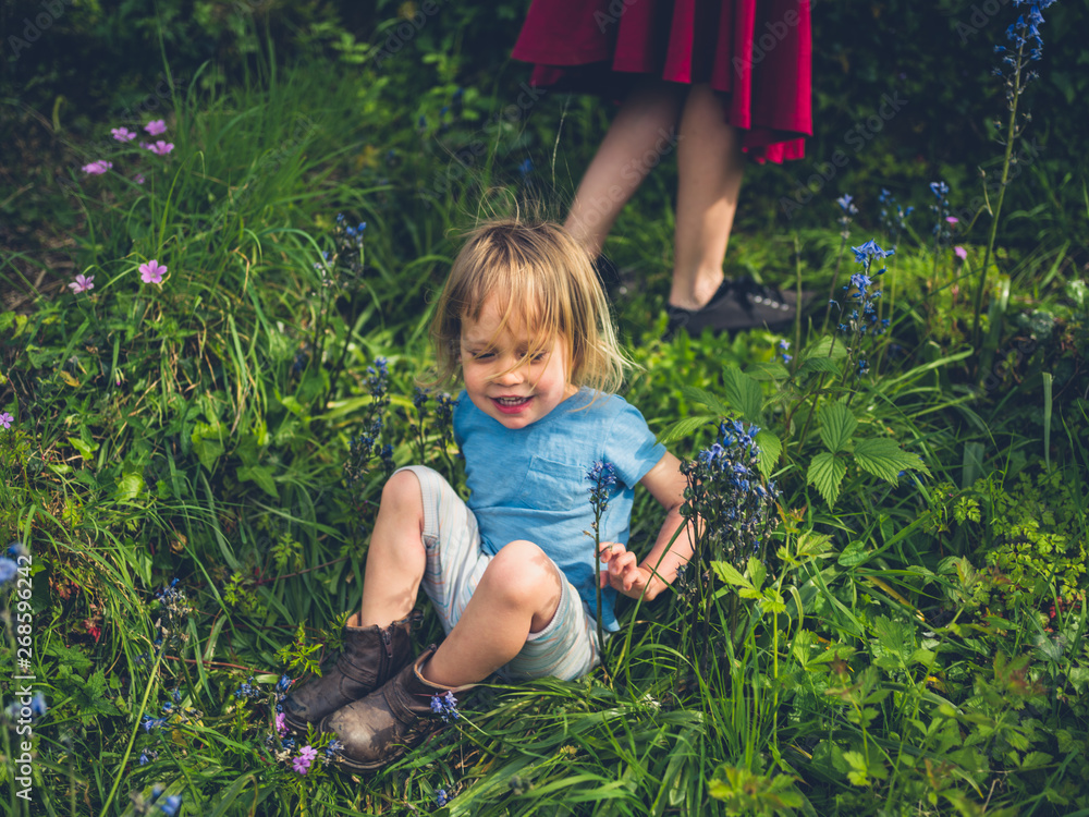 Little toddler sitting in garden with bluebells Little toddler sitting in garden with bluebells
