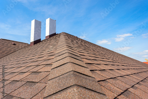 Fotografie, Obraz Asphalt tile roof with chimney on new home under construction