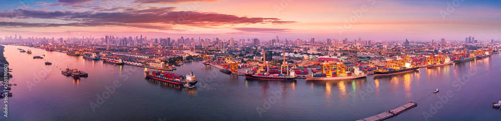Aerial panoramic view of Logistics and transportation of Container Cargo ship and Cargo plane with working crane bridge in shipyard at sunrise, logistic import export and transport industry background