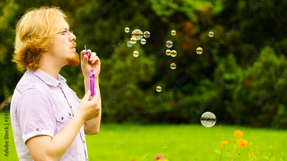Man blowing soap bubbles outdoor