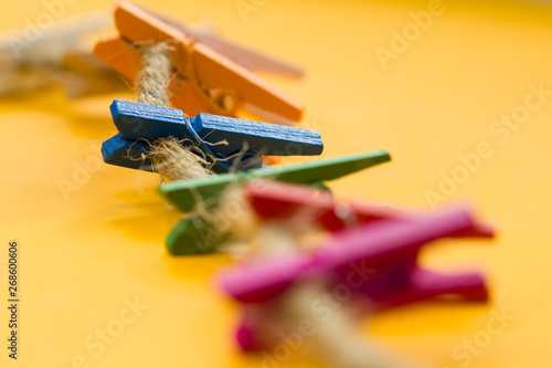 colored wooden clothespins hanging on a wire 