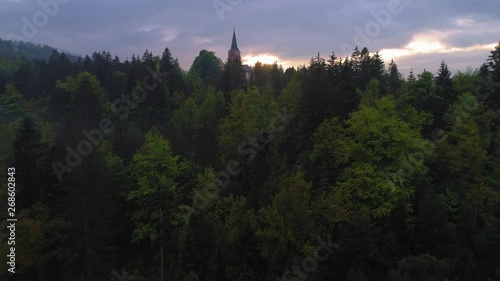 Flying over church on the hill with magical light after spring storm