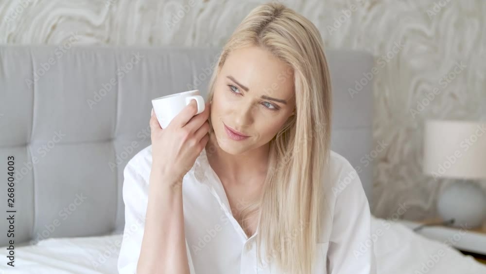 Adorable beautiful woman drinks coffee from the mug Adorable beautiful woman drinks coffee from the mug