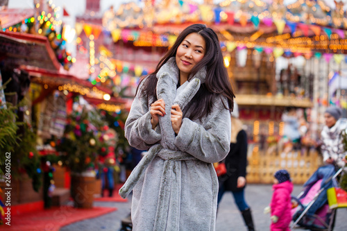 Happy asian woman in winter coat from faux fur