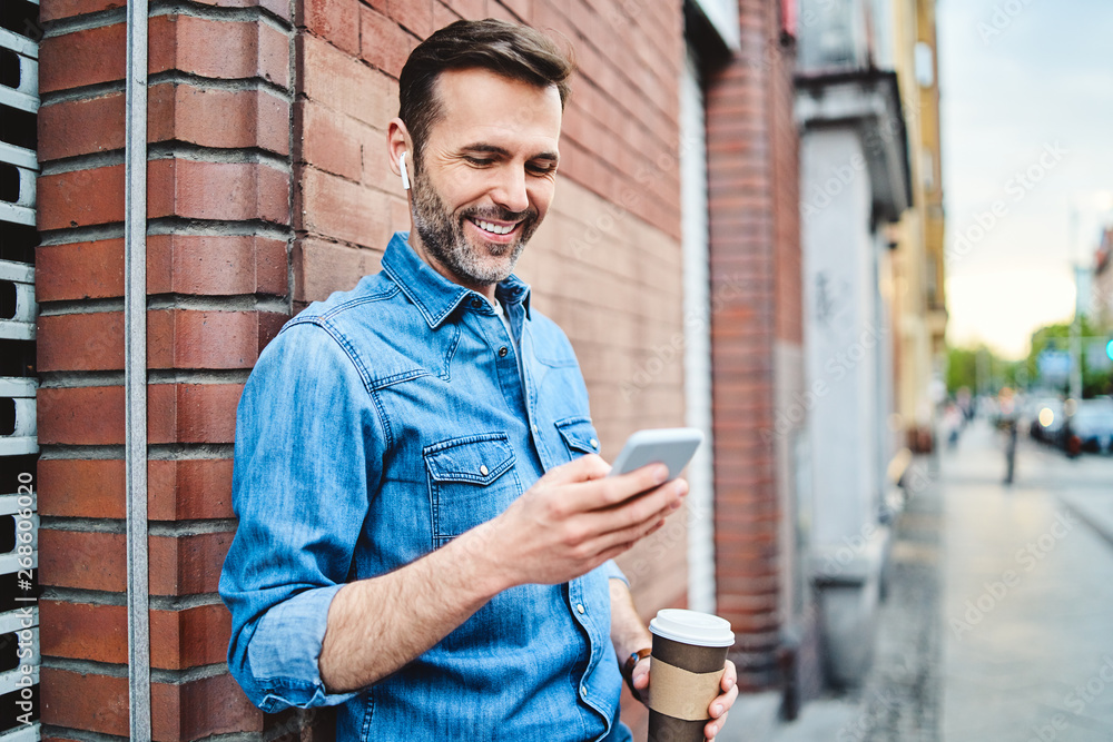 Φωτογραφία Portrait of man having phone call on wireless headphones out in the city