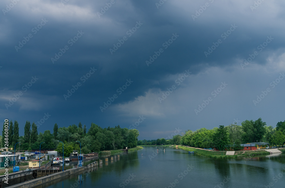 Czech river Labe (Elbe) in Pardubice with dramatic clouds