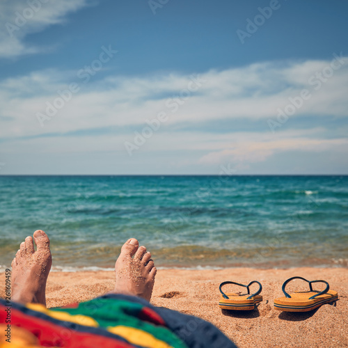 Man lying and enjoying on a sandy tropical beach.