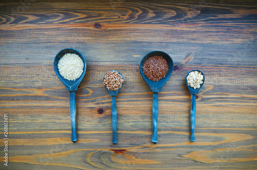 Four wooden spoons with cereals.