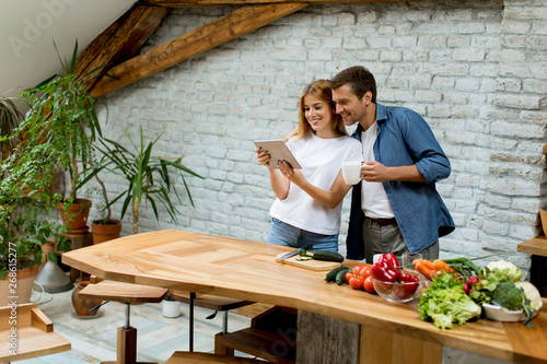 Lovely cheerful couple cook...