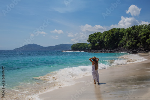 Happy  woman in white dress on tropical beach vacation
