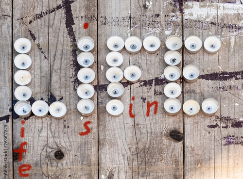 burnt telight candles as concept of human life on grunge wooden background photo