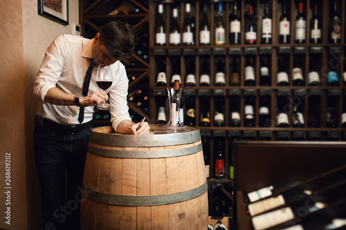 sommelier making notes while drinking wine at work. close up photo. copy space.creation of wine list