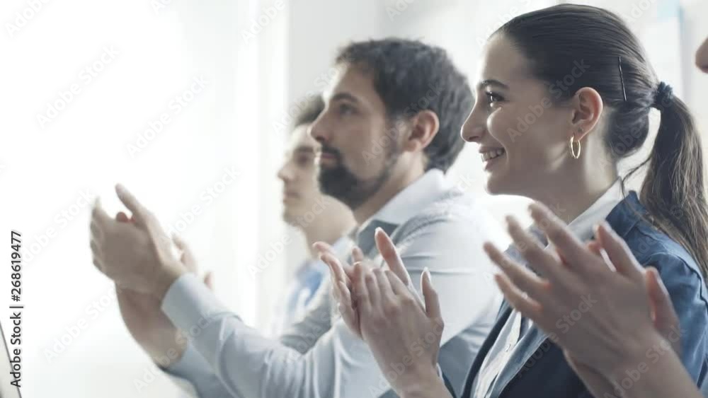 Cheerful business team applauding together and smiling Cheerful business team applauding together and smiling
