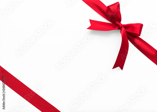 Fotografie Red bow satin ribbon band stripe fabric on corner (isolated on white background