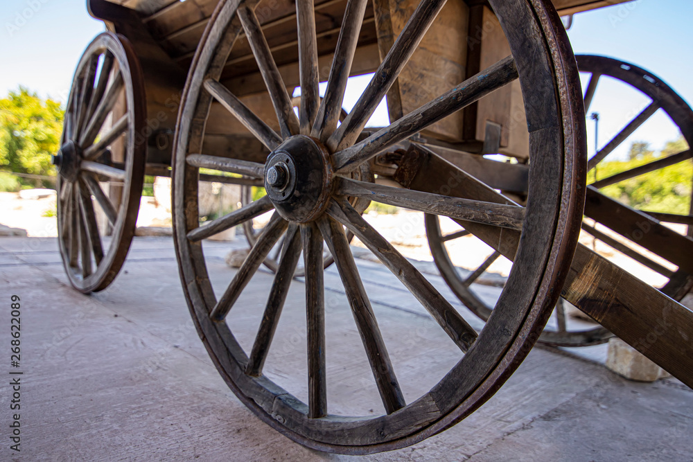 Side view of the wooden wheels of an ancient cart. The historic city of Zipory, Israel. Tourism and travel