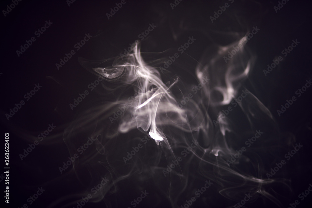 White smoke isolated on black background, fancifully spreads in the air. Monochrome. White smoke isolated on black background, fancifully spreads in the air. Monochrome.