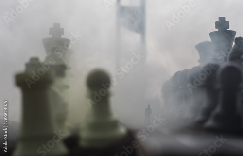 Chess concept of business and strategy ideas. Silhouette of a man standing in the middle of the road with giant chess figures and Guillotine. Artwork decoration