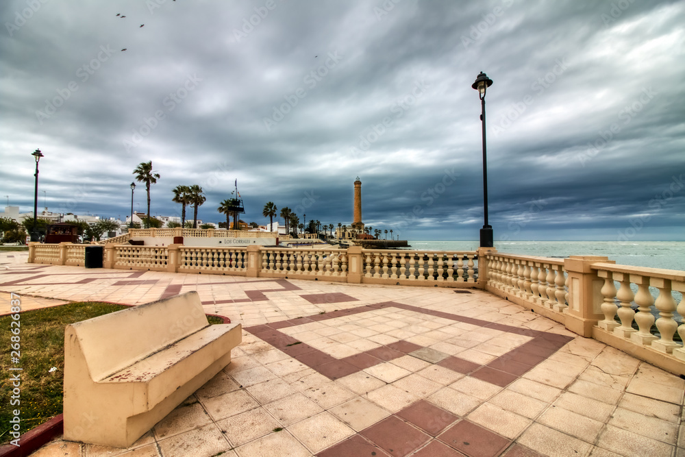 Promenade of Chipiona, in the province of Cadiz, Spain, with the lighthouse in the background on a stormy day
