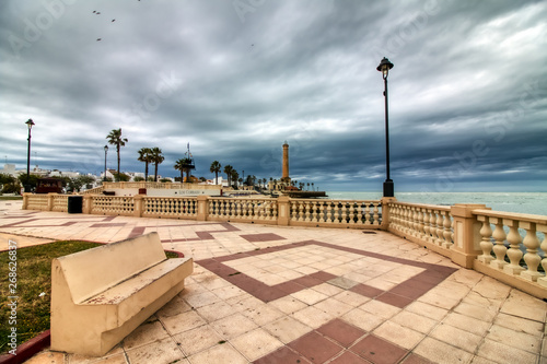 Promenade of Chipiona, in the province of Cadiz, Spain, with the lighthouse in the background on a stormy day © juanorihuela
