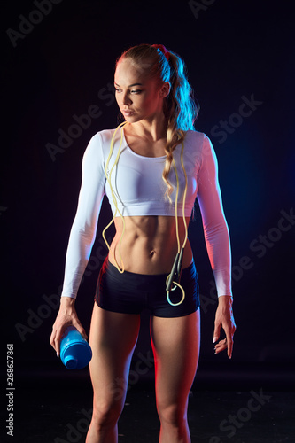 slim tired serious sportswoman having a rest after training. close up photo. isolated black background.active lifestyle, wellness, wellbeing © alfa27