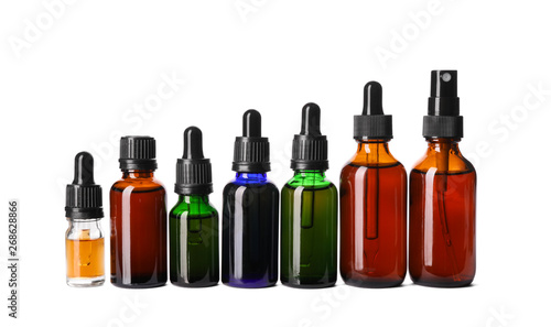Cosmetic bottles of essential oils on white background