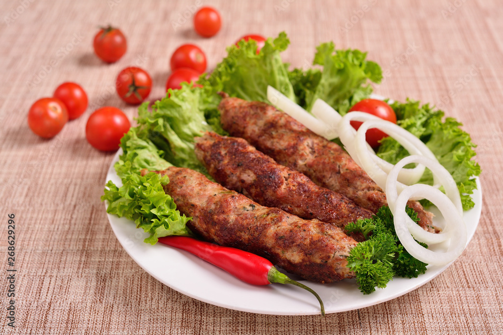 Lula kebab is a traditional Arabic dish. Meat shashlik on with tomato. Lula kebab is a traditional Arabic dish. Meat shashlik on with tomato.