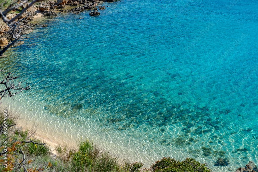Obraz premium View from a beach during summer, located on a beautiful island of Rab on the Adriatic coast in the heart of Mediterranean sea. Surrounded by the crystal clear turquoise sea and blue sky.