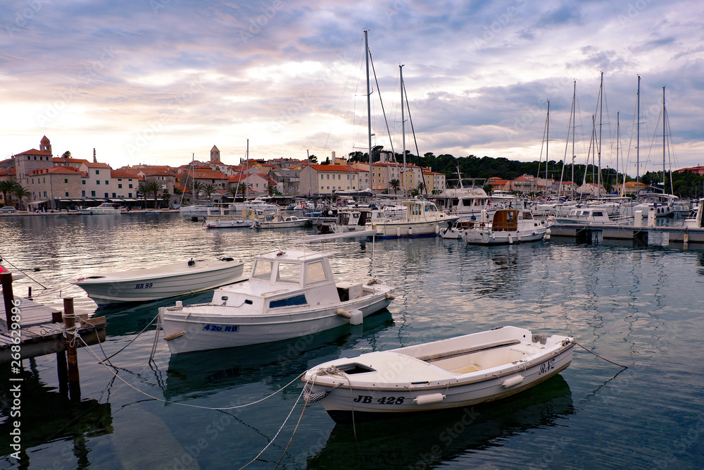 View of an ancient town of Rab, located on a beautiful island on the Adriatic coast in the heart of Mediterranean sea. Surrounded by the crystal clear turquoise sea and cloudy sky. View of an ancient town of Rab, located on a beautiful island on the Adriatic coast in the heart of Mediterranean sea. Surrounded by the crystal clear turquoise sea and cloudy sky.