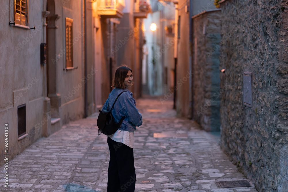 handsome tourist girl visiting narrow streets of old town in southern Italy, Basilicata Apulia region