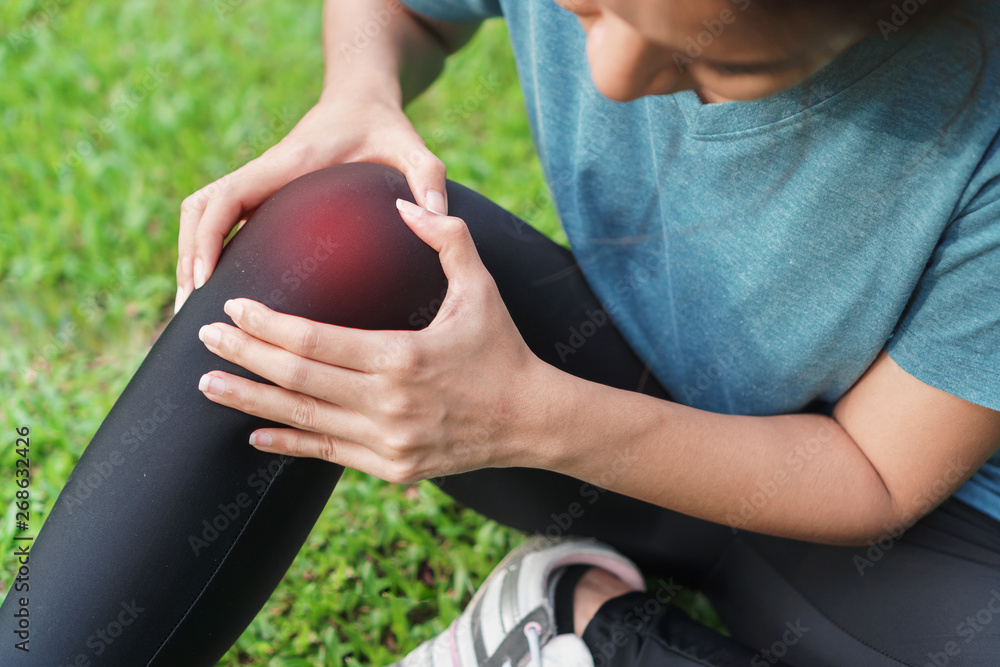 Young woman asian have accident knee twist sprain in sport exercise jogging, Selective focus,Exercise and healthy concept.