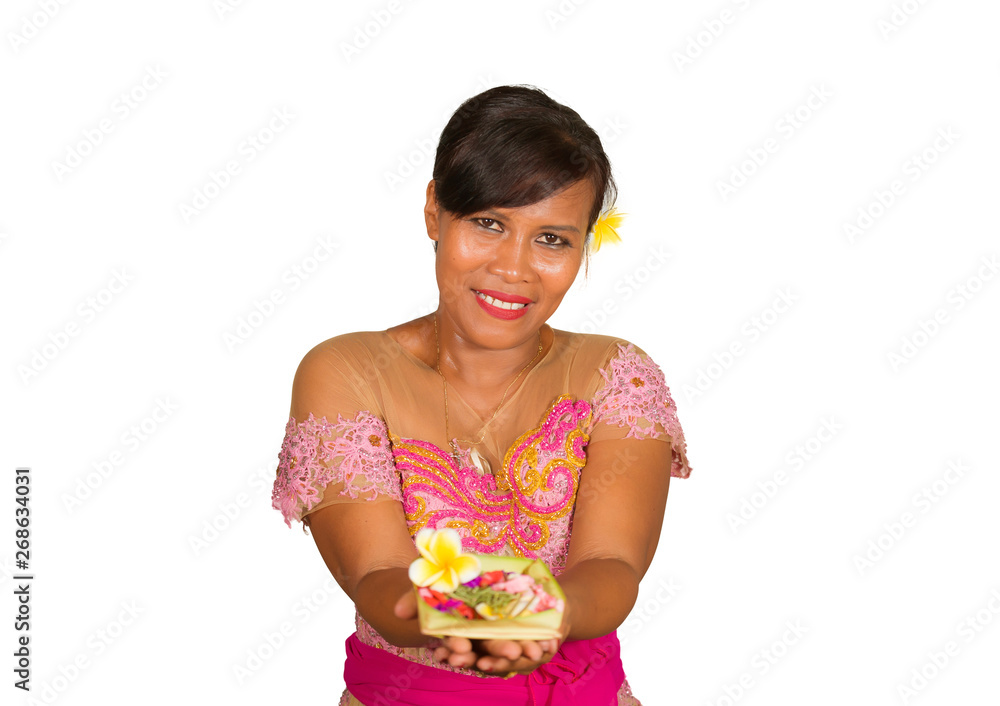 beautiful and happy middle aged Indonesian Balinese woman in traditional ceremony dress smiling and holding flower offering in her hands in welcome to Bali Hindu religion beautiful and happy middle aged Indonesian Balinese woman in traditional ceremony dress smiling and holding flower offering in her hands in welcome to Bali Hindu religion
