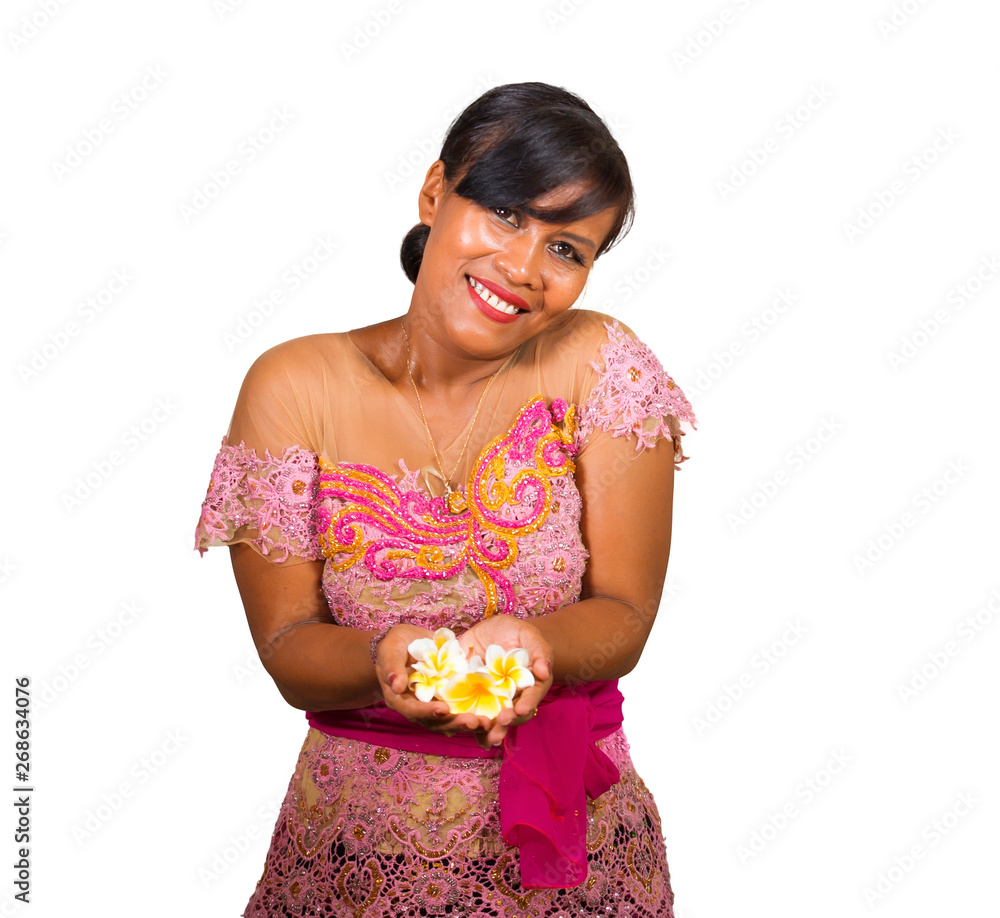 beautiful and happy middle aged Indonesian Balinese woman in traditional ceremony dress smiling and holding flower offering in her hands in welcome to Bali Hindu religion beautiful and happy middle aged Indonesian Balinese woman in traditional ceremony dress smiling and holding flower offering in her hands in welcome to Bali Hindu religion
