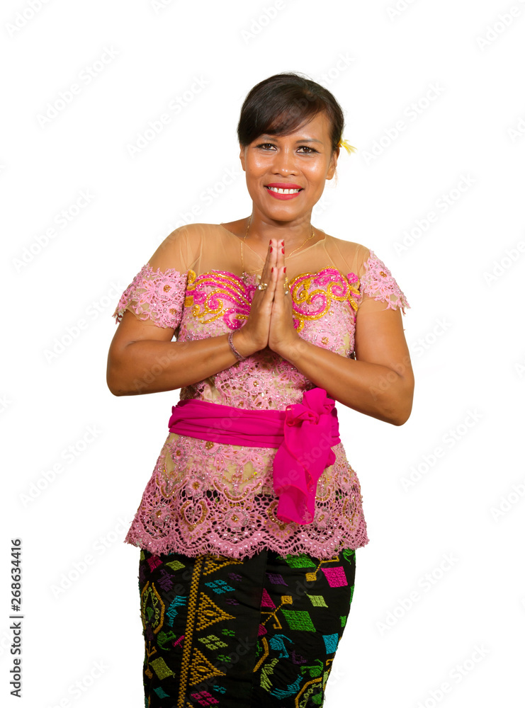 beautiful middle aged 40s Indonesian Balinese woman in traditional religious ceremony dress smiling cheerful on isolated background in welcome to Bali Hindu religion beautiful middle aged 40s Indonesian Balinese woman in traditional religious ceremony dress smiling cheerful on isolated background in welcome to Bali Hindu religion