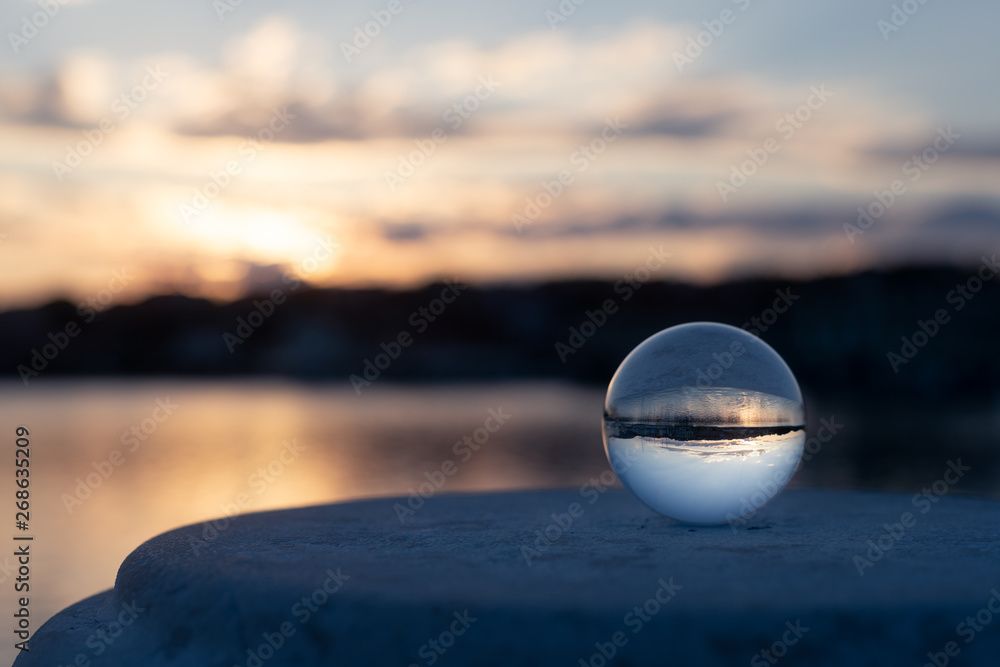 Sunset through glass ball in the harbor of Cres on a partly cloudy day in spring Sunset through glass ball in the harbor of Cres on a partly cloudy day in spring
