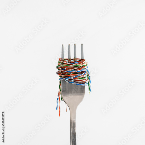 UTP cable wrapped around a steel fork like pasta or spaghetti on the white background.
