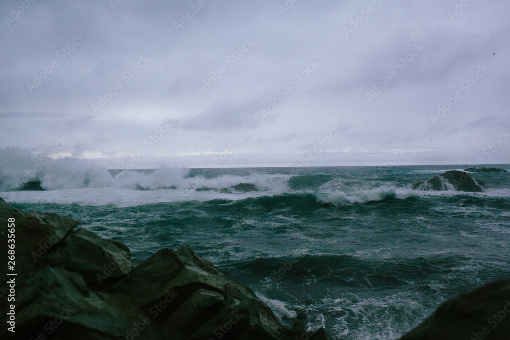 Waves of a raging dark sea crashing on rocks