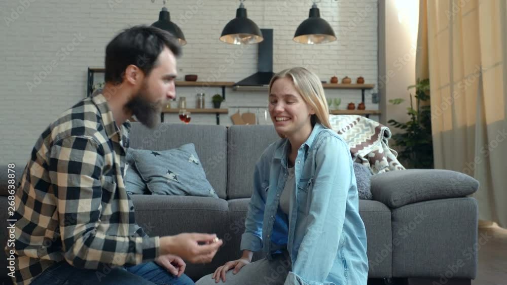 Happy couple joking at home. Guy throwing popcorn, while young woman trying to catch it. Happy couple joking at home. Guy throwing popcorn, while young woman trying to catch it.