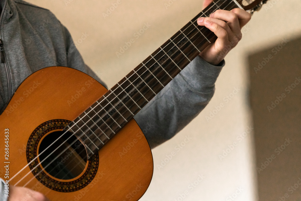 Fototapeta premium Young musician with wooden guitar