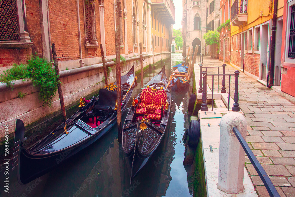 Venice, Italy. Gondolas in Venetian narrow water channel along houses