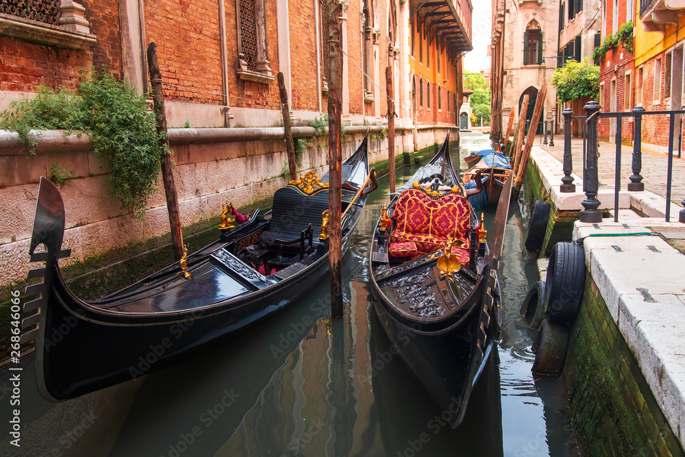 Gondolas in Venezia along old houses in narrow canal. Venice cityscape. Venetian street landscape