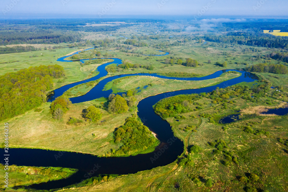 Aerial nature river background. Scenic river on green meadow from above. Drone view on river